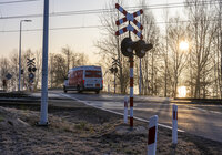 Widok z powietrza na przejazd kolejowo-drogowy i przejeżdżający po nim samochód. 